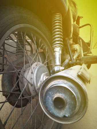 old retro style  motorcycle backside view near its silencer, suspension spring, tyre, rim of an old bikeの写真素材
