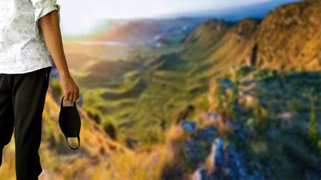 Asian man standing in mountains view point and removed mask after corona virus lock down ended...
