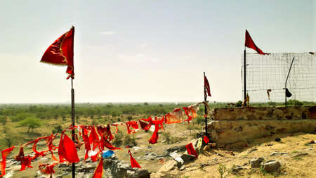 Hindu religious red flags fluttering on temple on a hill and horizon view point