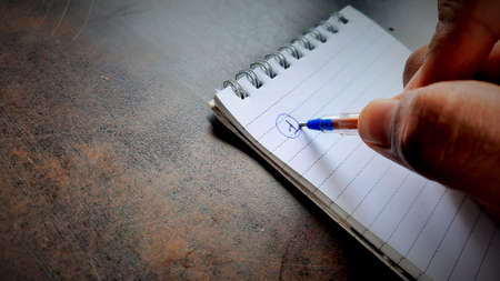 Asian businessman making notes on daily strategy or goals with vintage effectの写真素材
