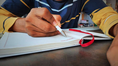 teenager writing tasks for daily routine in personal diaryの写真素材