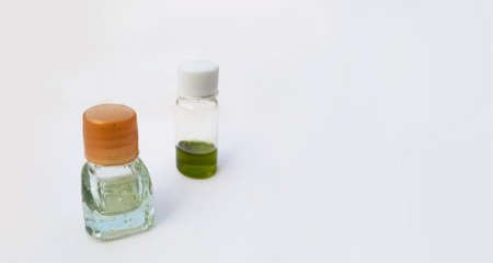 two small perfume or attar bottles isolated in white background with selective focusの写真素材