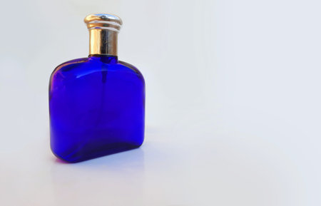 Royal blue colored transparent perfume bottle with silver cap isolated on whiteの写真素材