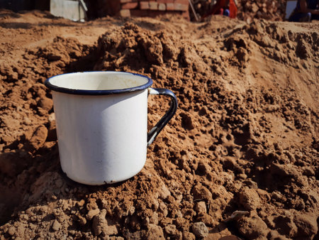 white mug on soil closeup with copy spaceの写真素材