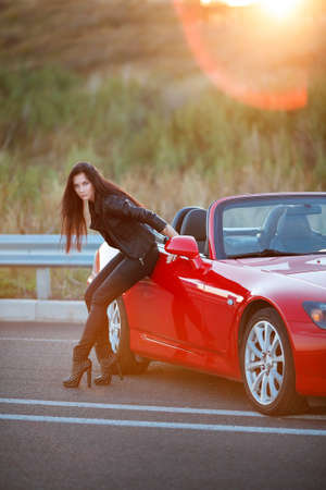 woman leaned on the door of a red carの写真素材