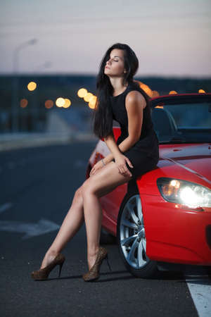 beauty portrait of a sexy woman on the street background with carの写真素材