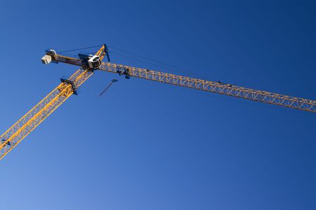 Construction crane against blue skyの写真素材