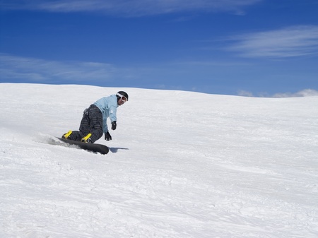 Snowboarder on ski slope against beautiful sky