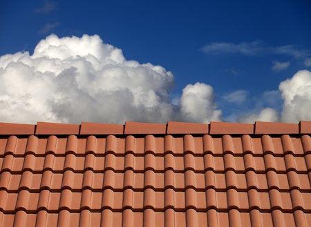 Roof tiles and blue sky with cloudsの写真素材