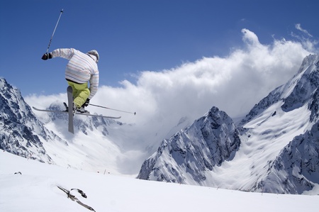 Freestyle ski jumper with crossed skis in high mountainsの写真素材