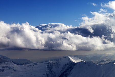 Winter mountains in evening and sunlight clouds. Caucasus Mountains, Georgia, view from ski resort...
