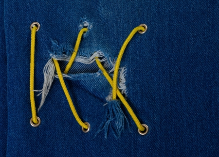 Blue jean with hole and crisscross yellow lacingの写真素材