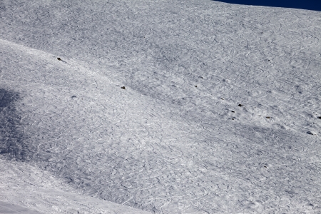 Traces of skis and snowboards on off-piste slope at sun dayの写真素材
