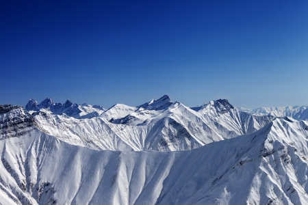 Snowy winter rocks in sun day, view from ski slope. Caucasus Mountains, Georgia, ski resort Gudauri.の写真素材