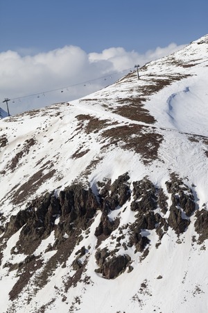 Off-piste slope with stones and chair-lift in little snow year. Caucasus Mountains, Georgia. Ski...