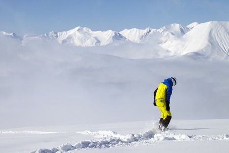 Snowboarder on off-piste slope with new fallen snow. Caucasus Mountains, Georgia, ski resort Gudauri.の写真素材