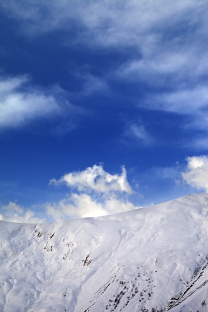 Off-piste slope and blue sky with clouds. Caucasus Mountains, Georgia, ski resort Gudauri.の写真素材