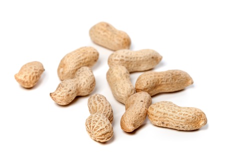 Unpeeled peanuts isolated on white background. Selective focus.