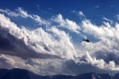 Helicopter in cloudy sky. Ski resort Gudauri. Caucasus Mountains, Georgia.の写真素材