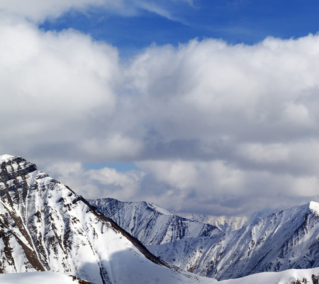 Winter snowy mountains in clouds at nice day. Caucasus Mountains, Georgia, view from ski resort Gudauri.の写真素材