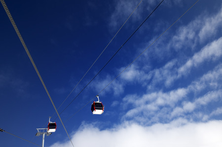 Gondola lifts at ski resort and blue sky with clouds in nice day. Wide angle, bottom view.の写真素材