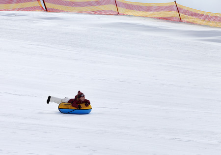 Snow tubing in ski resort at gray dayの写真素材