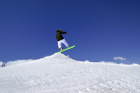 Snowboarder jump in snow park at ski resort on sun winter day. Caucasus Mountains, region Dombay.の写真素材