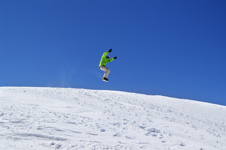 Snowboarder jump in snow park at ski resort on sun day. Caucasus Mountains, region Dombay. の写真素材