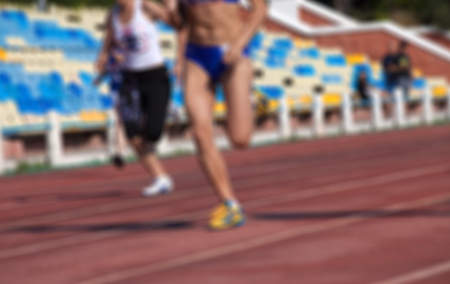 Blurred view of athletic running competition at stadium not in focus. Use as backgroundの写真素材