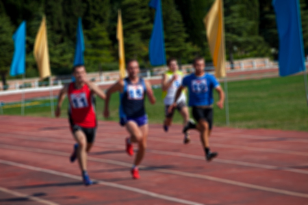 Blurred view of man athletic running competition at outdoor stadium not in focus. Use as background.の写真素材