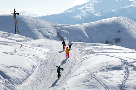 Skiers and snowboarders on snow road at sun winter morning. Caucasus Mountains, Georgia, region Gudauri.のeditorial素材