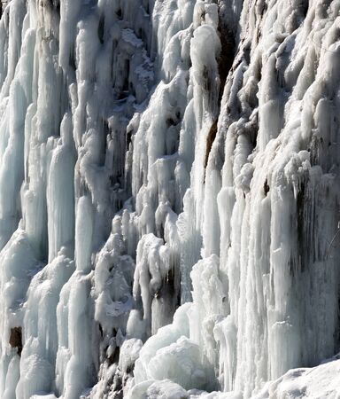 Icy mountain waterfall at cold sunny day. Winter in Georgia.の写真素材