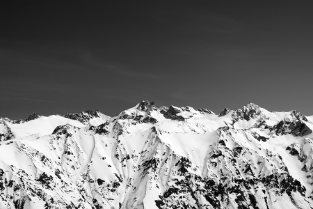 Black and white snow covered mountains at sun cold day. View from region Dombay, Caucasus Mountains in winter.の写真素材
