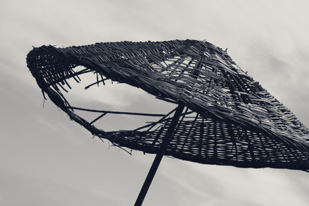 Black and white old sunshade with hole and gray skyの写真素材