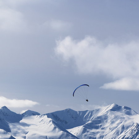Sky gliding in snowy sunlight mountains. Caucasus Mountains, Georgia, region Gudauri at winter.