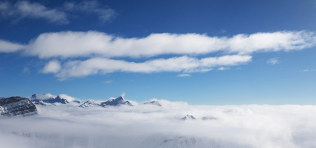 Panoramic view on sunlight mountains under clouds at nice sun day. Caucasus Mountains in winter, Georgia, region Gudauri. Viewpoint atop mount Kudebi.の写真素材