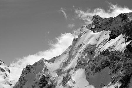 Black and white view on snowy mountains and cloudy skyの写真素材