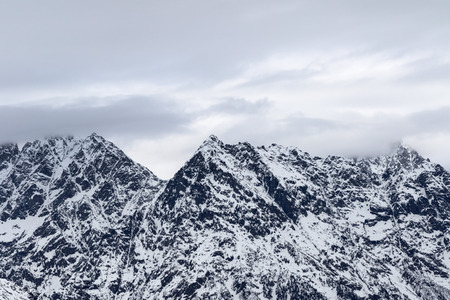 Rocky mountains in snow and cloudy gray sky at winter. Caucasus Mountains, Svaneti region of Georgia.の写真素材