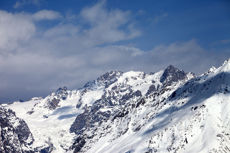 View on snowy mountains with glacier and cloudy blue sky in nice sunny day. Caucasus Mountains at winter. Svaneti region of Georgia.の写真素材