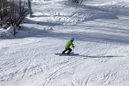 Skier descent on snowy ski slope at sunny winter day. Caucasus Mountains. Hatsvali, Svaneti region of Georgia.の写真素材