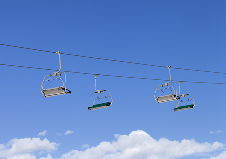 Sunlight ski-lift and blue sky with clouds at ski resort on sun winter dayの写真素材