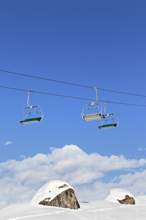 Sunlight chair-lift and blue sky with clouds at ski resort on sun cold day. Caucasus Mountains in winter, Shahdagh, Azerbaijan.の写真素材