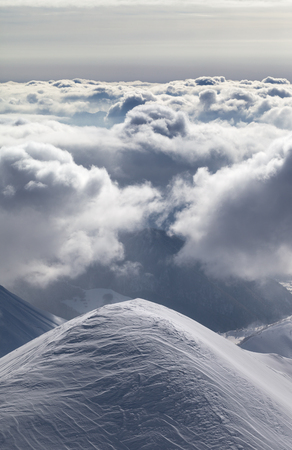 Snowy mountains in sunlight clouds at sun evening. Caucasus Mountains in winter, Georgia, region Gudauri.の写真素材
