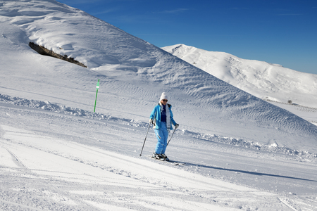 Skier downhill on snowy ski slope at nice sun day. Greater Caucasus in winter, Shahdagh, Azerbaijan.の写真素材