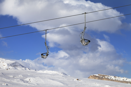 Snowy slope, ski-lift and blue sky with clouds at sun winter day. Caucasus Mountains, Shahdagh, Azerbaijan.の写真素材