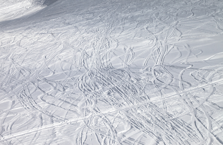 Snowy ski slope with trace from skis and snowboards at sunny winter eveningの写真素材