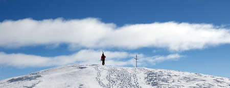 Skier with skis on his shoulder go up to top of mountain in nice sun day. Caucasus Mountains in winter, Georgia, region Gudauri, Mount Kudebi. Panoramic view.の写真素材