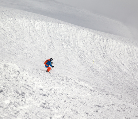 Skier downhill on freeriding slope and overcast misty sky before blizzard at winter dayの写真素材