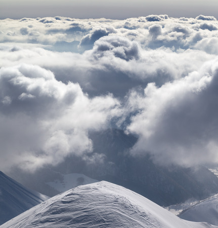 Snowy mountains in sunlight clouds at sunny evening. Caucasus Mountains in winter, Georgia, region Gudauri.の写真素材