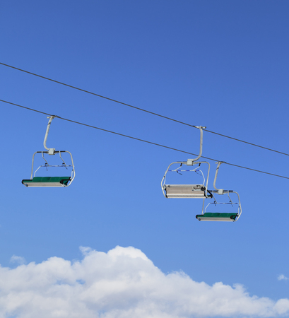 Sunlight chair-lift and blue sky with clouds at ski resort on sun winter dayの写真素材